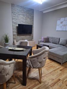 a living room with a couch and a table and chairs at Apartmani Radulović in Vrnjačka Banja