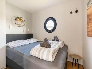 a bedroom with a bed with a round mirror at Wave in Volendam