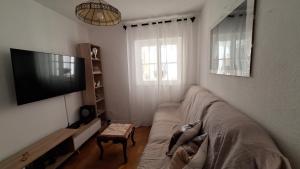 a living room with a couch and a flat screen tv at Pescadores GuestHouse in Costa da Caparica