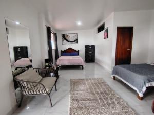 a bedroom with two beds and a chair in it at Cuarto en galápagos in Puerto Baquerizo Moreno