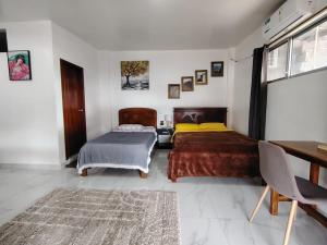 a bedroom with two beds and a desk at Cuarto en galápagos in Puerto Baquerizo Moreno