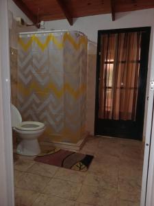 a bathroom with a shower curtain and a toilet at Hospedaje Nely in San Vicente +6 photos