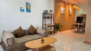 a living room with a couch and a table at Hatyai marina Villa in Ban Khlong Hae