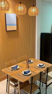 a wooden table with four chairs and a television at Hatyai marina Villa in Ban Khlong Hae