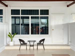 two chairs and a table in front of a window at Hatyai marina Villa in Ban Khlong Hae