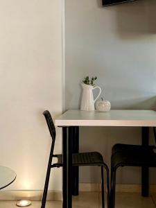 a table with a white pitcher and two chairs at A & D Houses in Patra