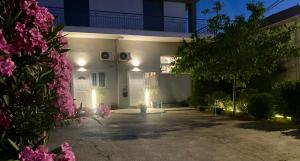 a white house with pink flowers in front of it at A & D Houses in Patra
