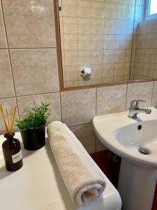 a bathroom with a sink and a toilet and a mirror at A & D Houses in Patra +16 photos