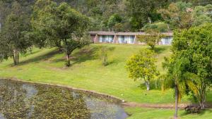 a house on a hill next to a lake at Cedar Lake Country Resort in Nerang