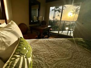 a bedroom with a bed with a view of a balcony at Oceanview Studio at Kauai Beach Resort #2444 in Lihue