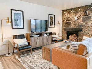 a living room with a television and a fireplace at Modern Mountainside Chalet in Steamboat Springs