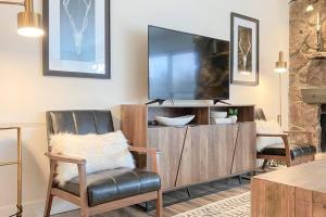 a living room with a flat screen tv on a entertainment center at Modern Mountainside Chalet in Steamboat Springs
