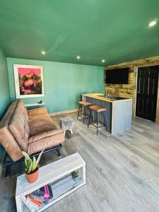 a living room with a couch and a tv and a table at Self contained cabin - The VenU in Bristol +18 photos