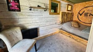 a room with a fireplace and a bed and a chair at Self contained cabin - The VenU in Bristol