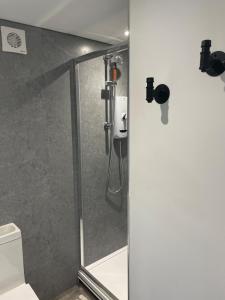 a bathroom with a shower with a glass door at Self contained cabin - The VenU in Bristol