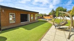 a house with a yard with a swing at Self contained cabin - The VenU in Bristol