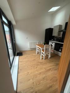 a living room with a table and a kitchen at Beeston Bungalow in Nottingham