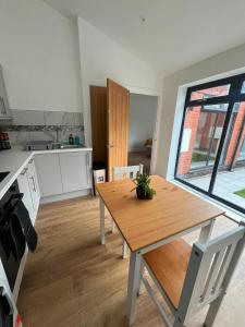 a kitchen with a wooden table and a dining room at Beeston Bungalow in Nottingham