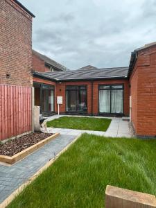 a brick house with green grass in front of it at Beeston Bungalow in Nottingham