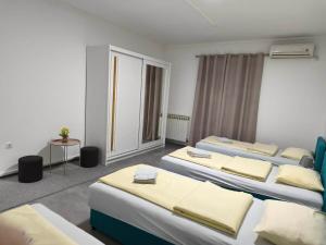 a hotel room with four beds and a table at Markaz Apartman Bihac in Bihać