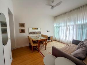 a living room with a table and a couch at Dream Home Icaraí Niterói in Niterói