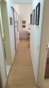 a hallway leading to a room with white walls and wood floors at Dream Home Icaraí Niterói in Niterói