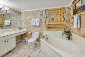 a bathroom with a tub and a toilet and a sink at Beach Club 436 in Saint Simons Island
