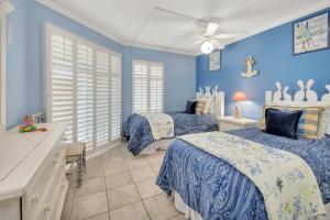 a bedroom with two beds and blue walls at Beach Club 436 in Saint Simons Island +16 photos