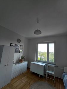 a white room with a desk and a window at Kawalerka nad Odrą in Brzeg