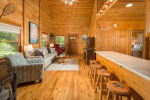 a log cabin living room with a couch and a bar at Serenity Summit in Banner Elk