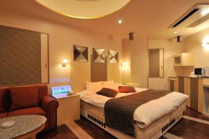 a bedroom with a bed and a chair and a laptop at Hotel Venus Ritz (Adult Only) in Seto
