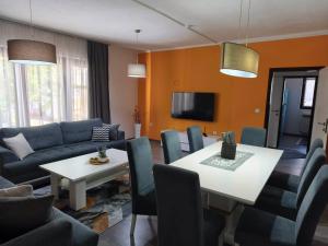 a living room with a couch and a table and chairs at Markaz Apartman Bihac in Bihać