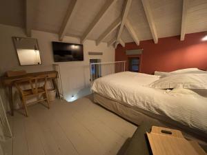 a bedroom with a bed and a table and a tv at Pirrion Villas in Ano Pedina