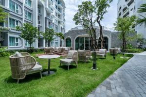 a patio with chairs and tables in the grass at Serenity by Pavol in Ban Bo Han