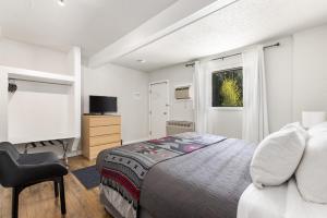 a bedroom with a bed and a chair and a window at The Hitching Post Motel in Pemberton