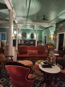 a living room with a couch and a table and chairs at Hotel Klaus in Opelousas