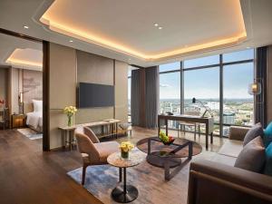 a hotel room with a living room with a view at Pullman Hai Phong Grand Hotel in Hai Phong