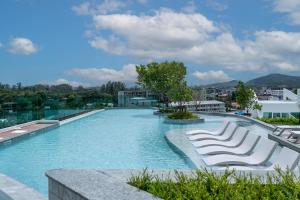 a large swimming pool with lounge chairs on a building at Serenity by Pavol in Ban Bo Han