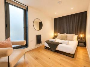 a bedroom with a large bed and a large window at Luxury Townhouse 4BR I Roof Terrace I Free Parking in Manchester