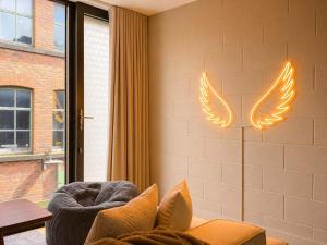 a living room with a couch with wings on the wall at Luxury Townhouse 4BR I Roof Terrace I Free Parking in Manchester +26 photos