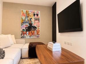 a living room with a white couch and a flat screen tv at Luxury Townhouse 4BR I Roof Terrace I Free Parking in Manchester
