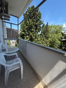 a white chair and a table on a balcony at Bar City Apt in Bar +1 photo
