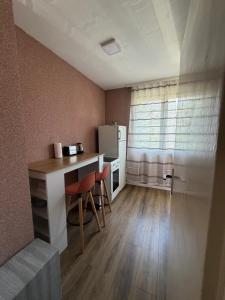 a small kitchen with a table and a refrigerator at Bar City Apt in Bar