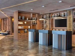 a lobby with a bar with vases on the shelves at Novotel Valencia Lavant in Valencia