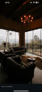 a living room with couches and a large window at Cabanas Rancho Alcântara in Treviso