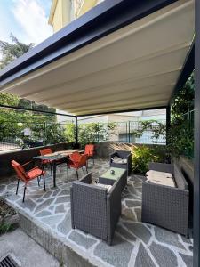 a patio with chairs and a table under awning at Central Cernobbio - Modern apartment in Cernobbio
