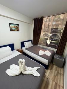 a room with two beds with towels on them at The Rivénto Boutique with Breakfast - Downtown,Cairo in Cairo