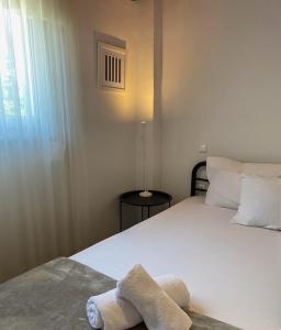 a bedroom with a white bed with a towel on it at A & D Houses No2 in Patra