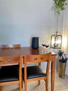 a wooden table with two glasses of wine at A & D Houses No2 in Patra