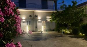 a white house with pink flowers in front of it at A & D Houses No2 in Patra